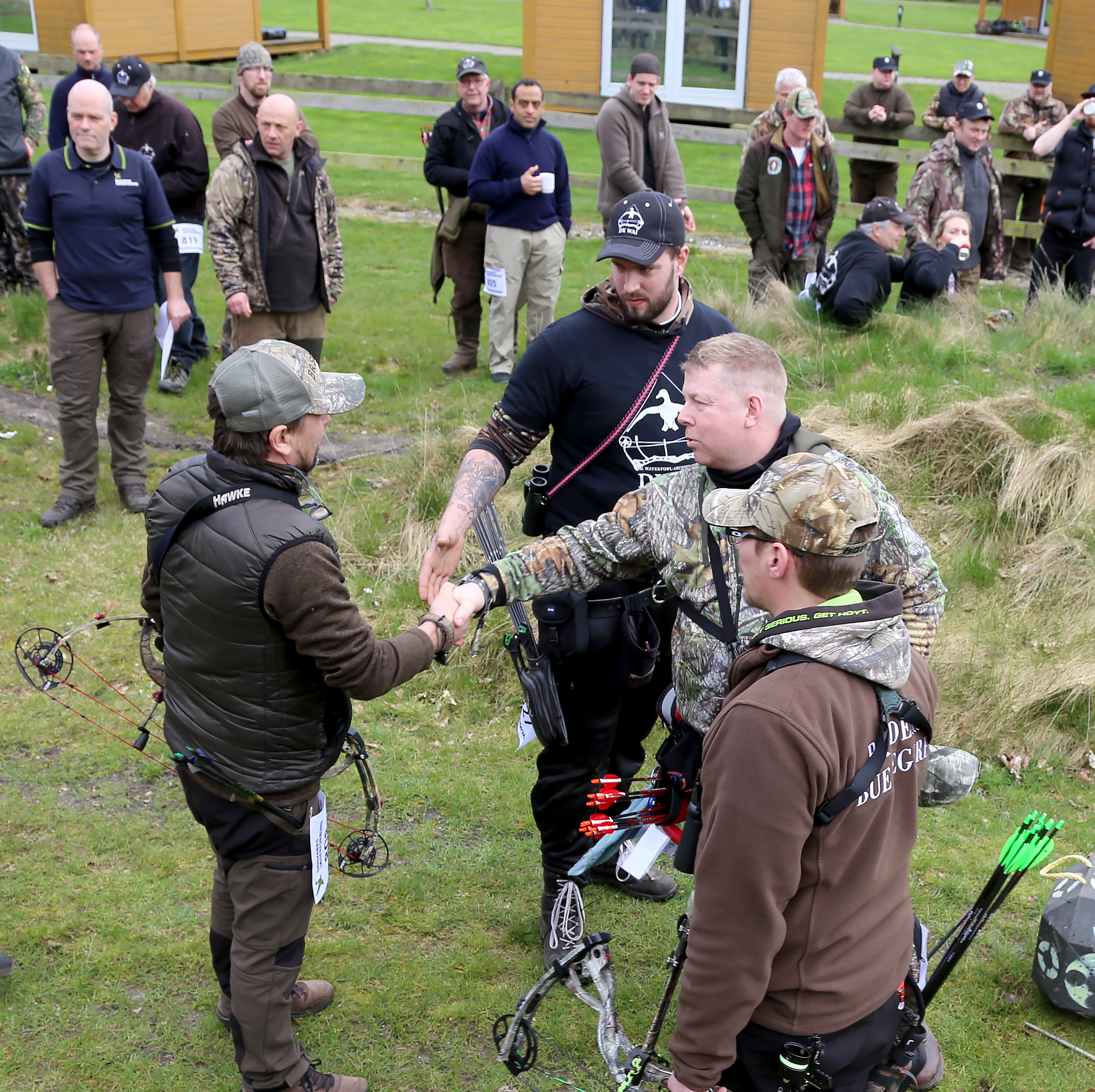 Omskydningen i compound er netop overstået, og Orla Hansen (tv) lykønskes af bronzevinderen Jesper Hansen, og de to andre deltagere i omskydningen, Jacob Steffensen og Eigil Frey.